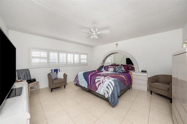 bedroom with ceiling fan, a textured ceiling, and light tile patterned floors