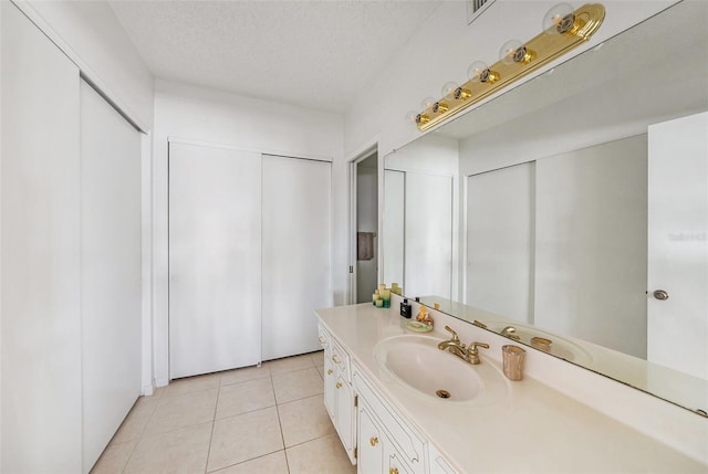 bathroom with vanity, a textured ceiling, and tile patterned floors