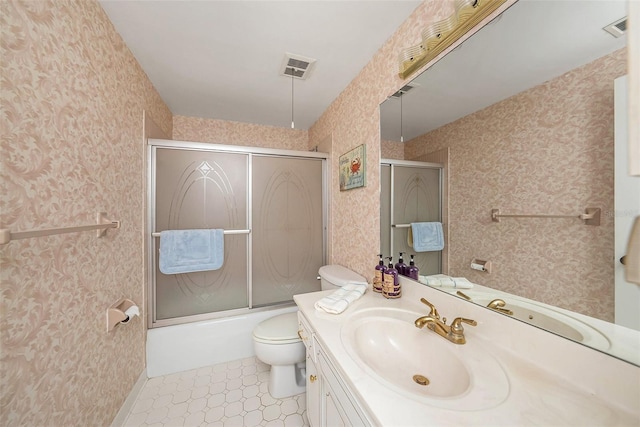 full bathroom featuring bath / shower combo with glass door, vanity, and toilet