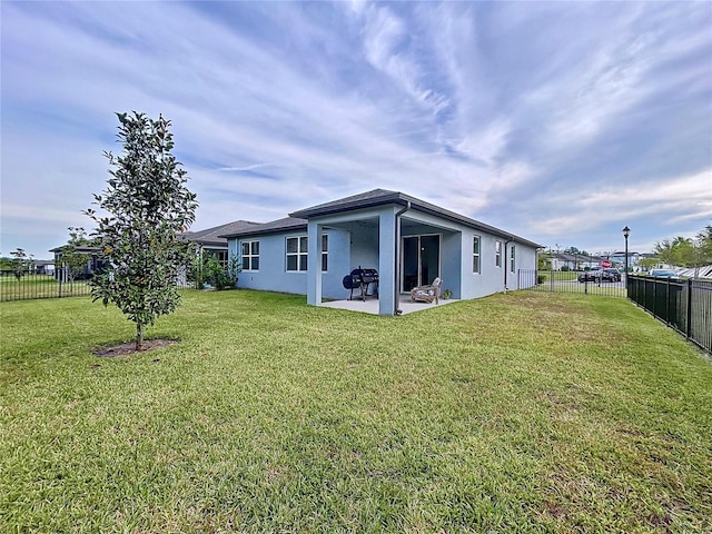 rear view of property featuring a yard and a patio area