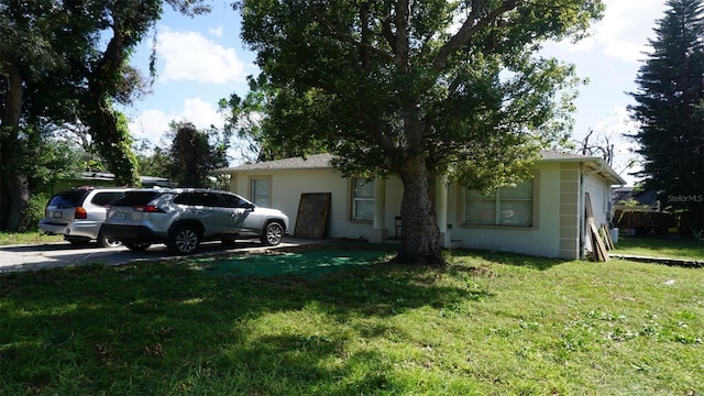 single story home with stucco siding and a front lawn