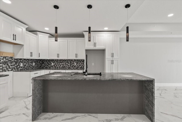 kitchen featuring pendant lighting, dark stone countertops, white cabinetry, and a kitchen island with sink