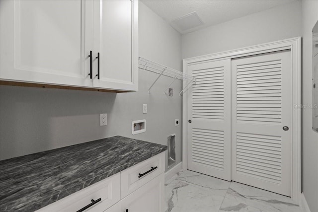 clothes washing area with electric dryer hookup, cabinets, a textured ceiling, and hookup for a washing machine