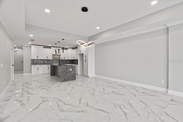 kitchen featuring white cabinetry, a kitchen island, pendant lighting, and ornamental molding