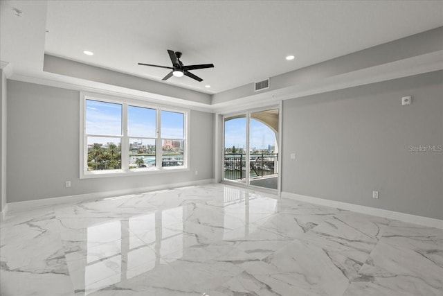 spare room featuring ceiling fan, a raised ceiling, and ornamental molding