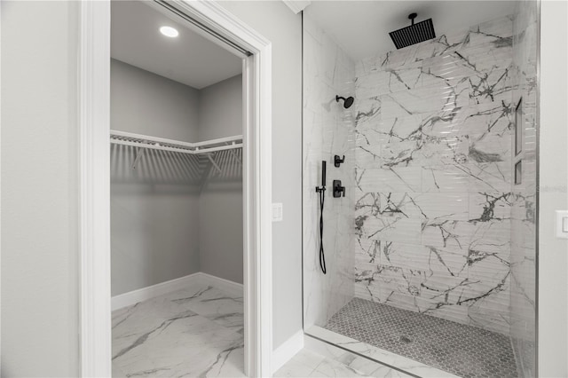211 Dolphin Pt Unit 202, Clearwater Beach, FL 33767 - full bath featuring marble look tiles, a marble finish shower, and a spacious closet