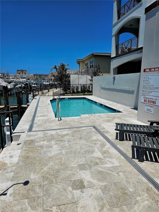 view of pool with a patio area and a water view