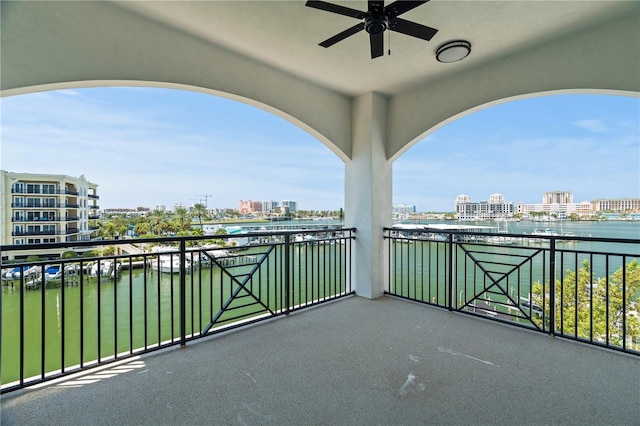 balcony with ceiling fan and a water view