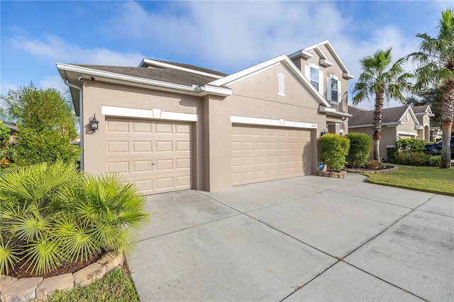 view of front facade featuring concrete driveway, a garage, and stucco siding