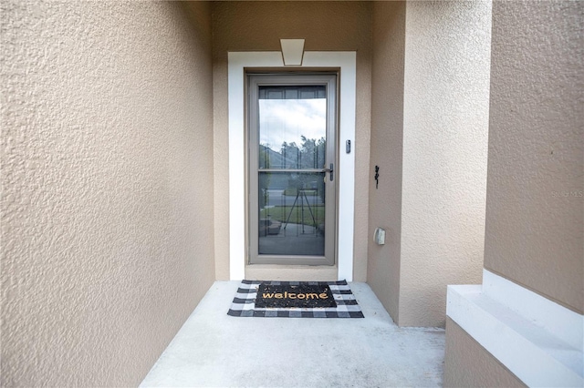 doorway to property with stucco siding