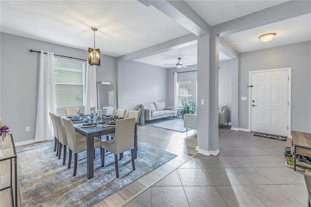 dining room featuring baseboards and ceiling fan with notable chandelier