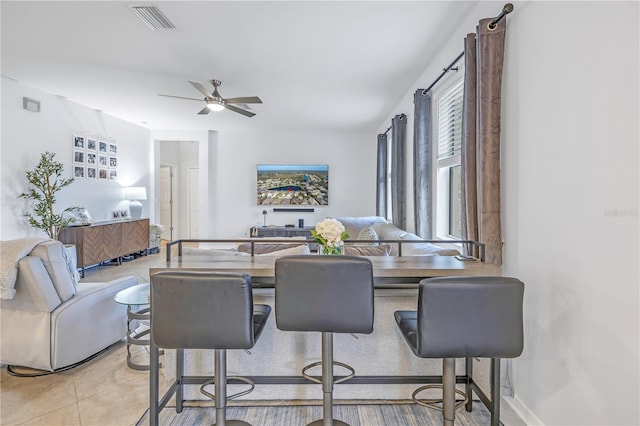dining space featuring tile patterned flooring, ceiling fan, and visible vents