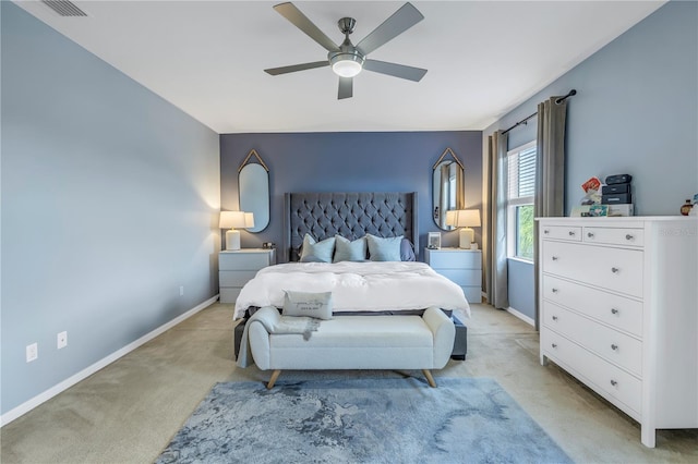bedroom with a ceiling fan, baseboards, visible vents, and light carpet