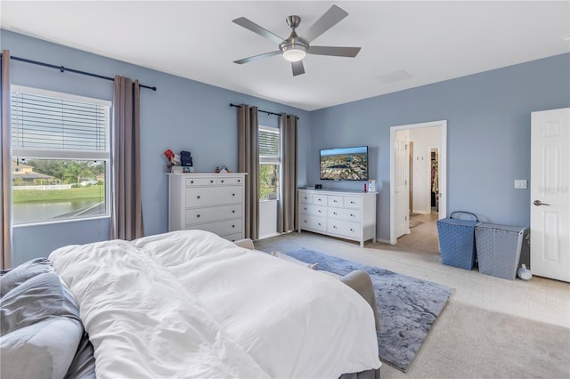 bedroom with a ceiling fan and light carpet