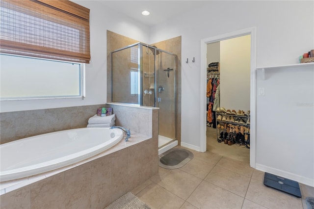bathroom featuring a garden tub, tile patterned floors, a spacious closet, and a shower stall