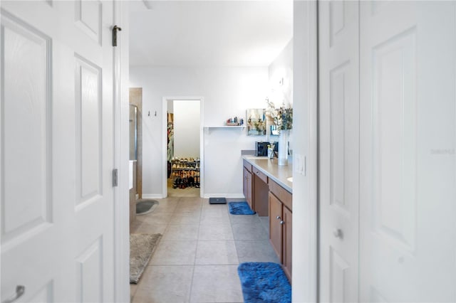 full bathroom featuring vanity, tile patterned flooring, baseboards, and a closet