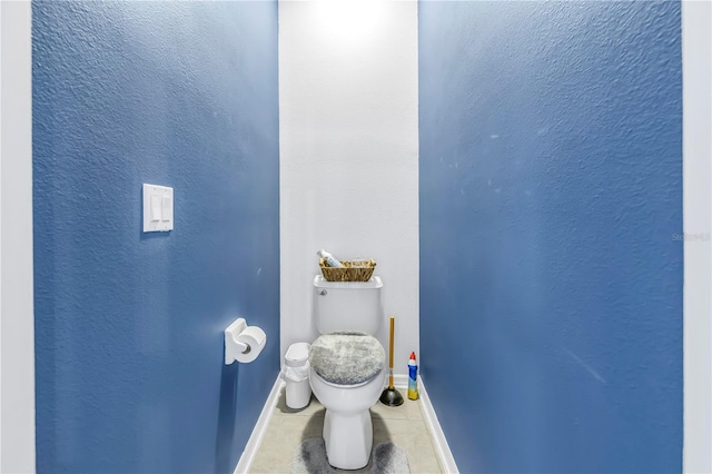 bathroom with tile patterned floors, baseboards, and toilet