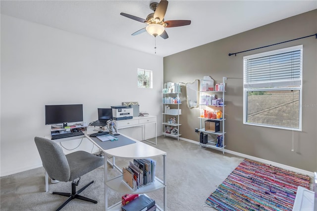 office space with light colored carpet, baseboards, ceiling fan, and a wealth of natural light