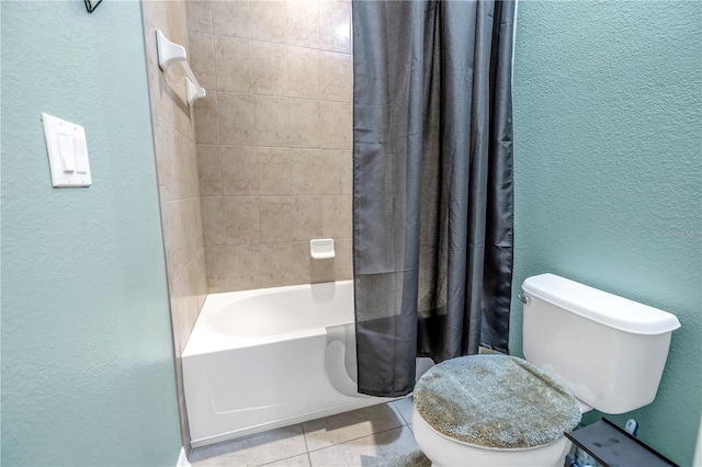 bathroom featuring toilet, a textured wall, tile patterned floors, and shower / bath combo