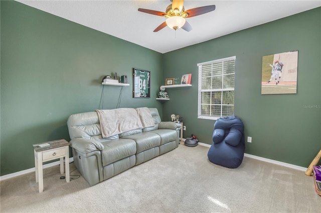 carpeted living area featuring baseboards and ceiling fan