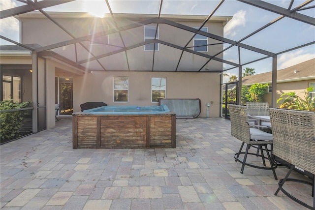 view of patio / terrace featuring glass enclosure and a hot tub