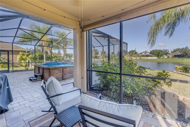 sunroom featuring a water view and a hot tub