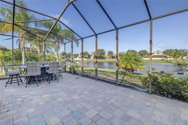 view of patio / terrace with a water view, a lanai, and an outdoor bar