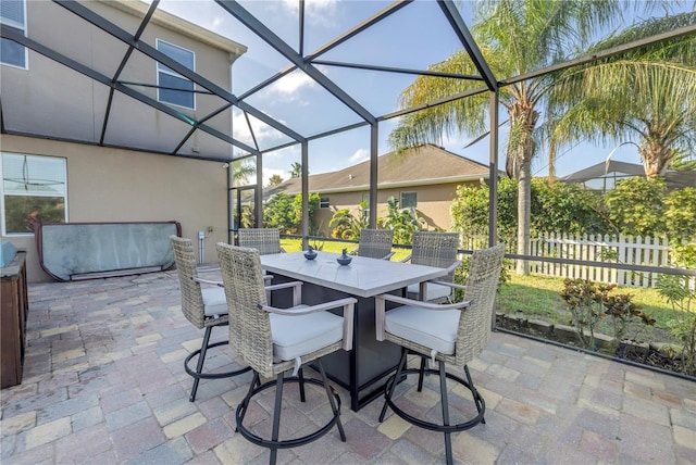 view of patio with fence, a lanai, and outdoor dining area