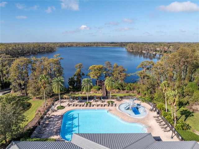 pool with a view of trees, a water view, and a patio area