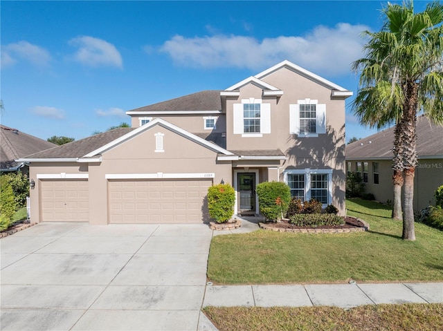 traditional home with concrete driveway, an attached garage, a front lawn, and stucco siding