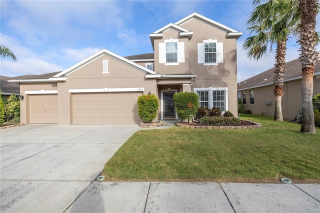 traditional home featuring an attached garage, driveway, a front lawn, and stucco siding
