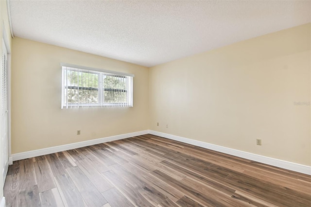 spare room featuring hardwood / wood-style floors and a textured ceiling