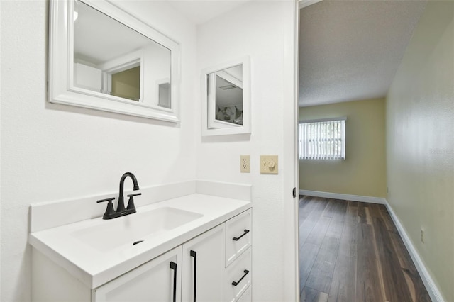 bathroom with vanity, a textured ceiling, and wood-type flooring