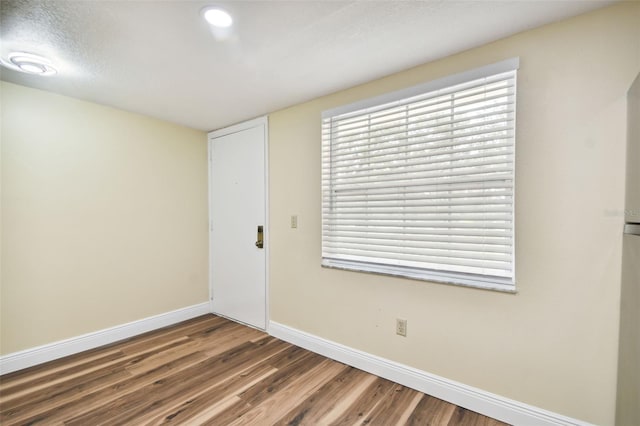 spare room featuring wood-type flooring and a textured ceiling