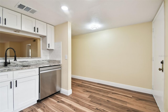 kitchen with sink, dishwasher, white cabinetry, and light hardwood / wood-style floors