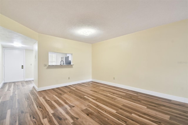 unfurnished room featuring a textured ceiling and wood-type flooring