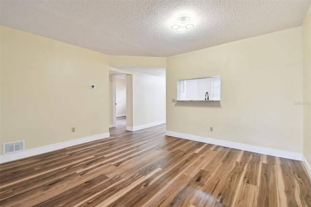 spare room with sink, wood-type flooring, and a textured ceiling