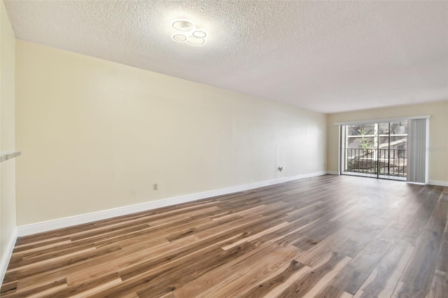 unfurnished room featuring a textured ceiling and hardwood / wood-style flooring