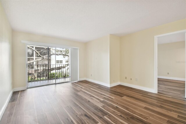 unfurnished room featuring a textured ceiling and hardwood / wood-style floors