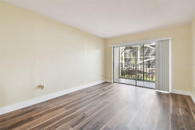 empty room with a textured ceiling and hardwood / wood-style flooring