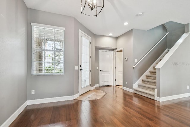 entryway with hardwood / wood-style floors and an inviting chandelier