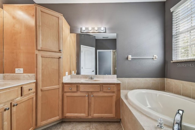 bathroom featuring tile patterned floors, vanity, and tiled tub