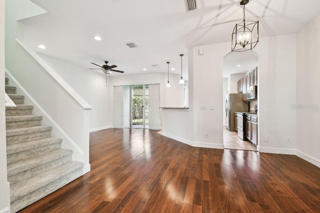 unfurnished living room featuring visible vents, dark wood finished floors, stairway, and baseboards