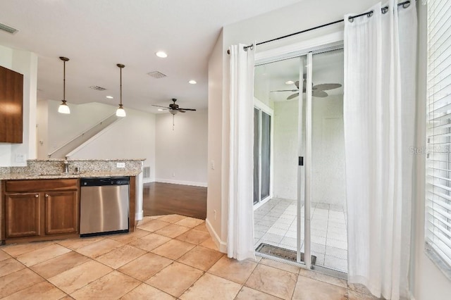 kitchen featuring decorative light fixtures, brown cabinetry, a ceiling fan, light stone countertops, and dishwasher