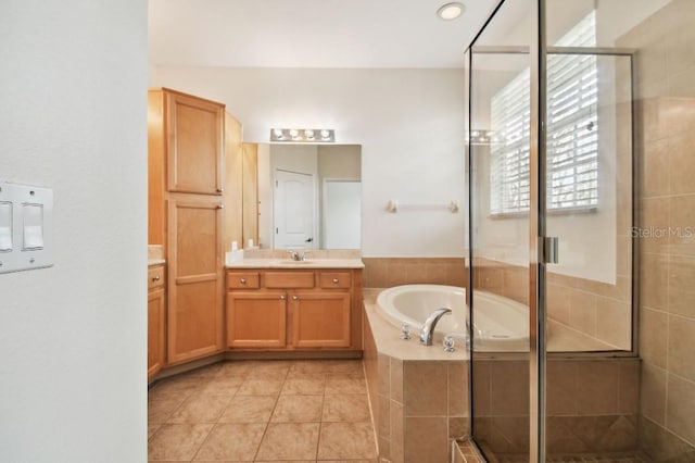 bathroom featuring a bath, a shower stall, vanity, and tile patterned floors