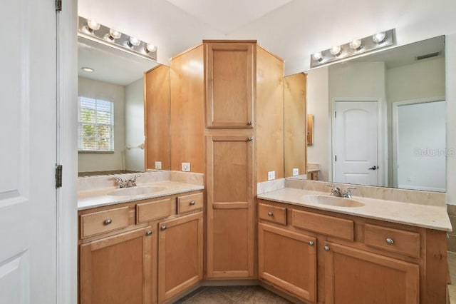 full bathroom with visible vents, two vanities, and a sink