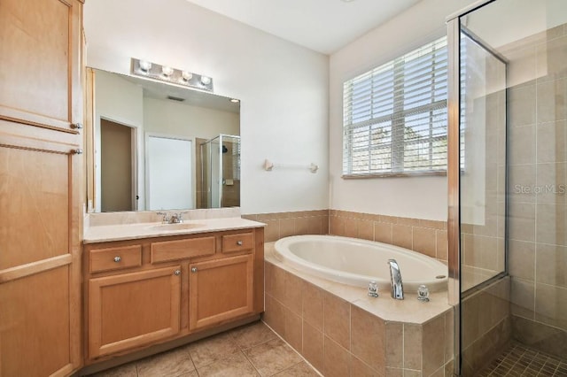 full bathroom with a garden tub, a shower stall, vanity, and tile patterned floors