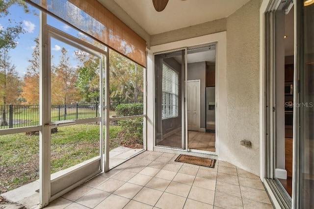 unfurnished sunroom featuring a ceiling fan