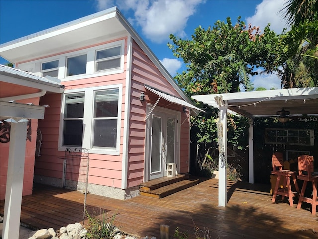 view of home's exterior with ceiling fan and a deck