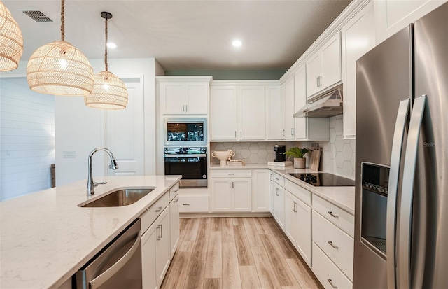 kitchen with pendant lighting, stainless steel appliances, sink, and white cabinets